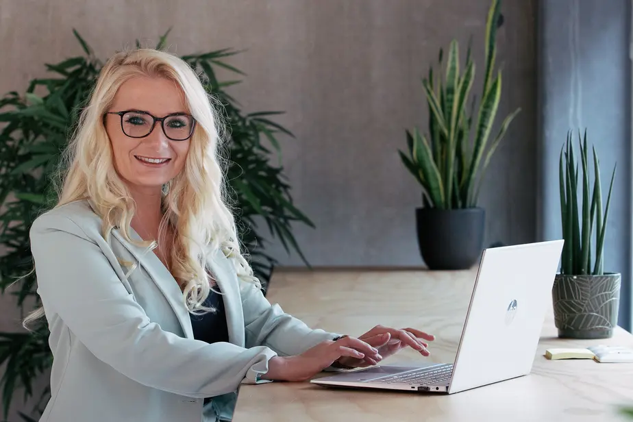 Darcie Hudson, founder of Go Ahead HiRe, smiling while reviewing a candidate CV on her laptop in the Reutum office